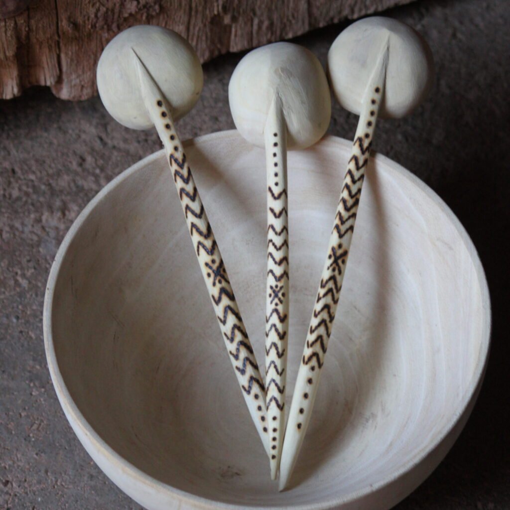 Trois cuillères artisanales en bois de tamarinier, décorées à la main de motifs géométriques amazighs.