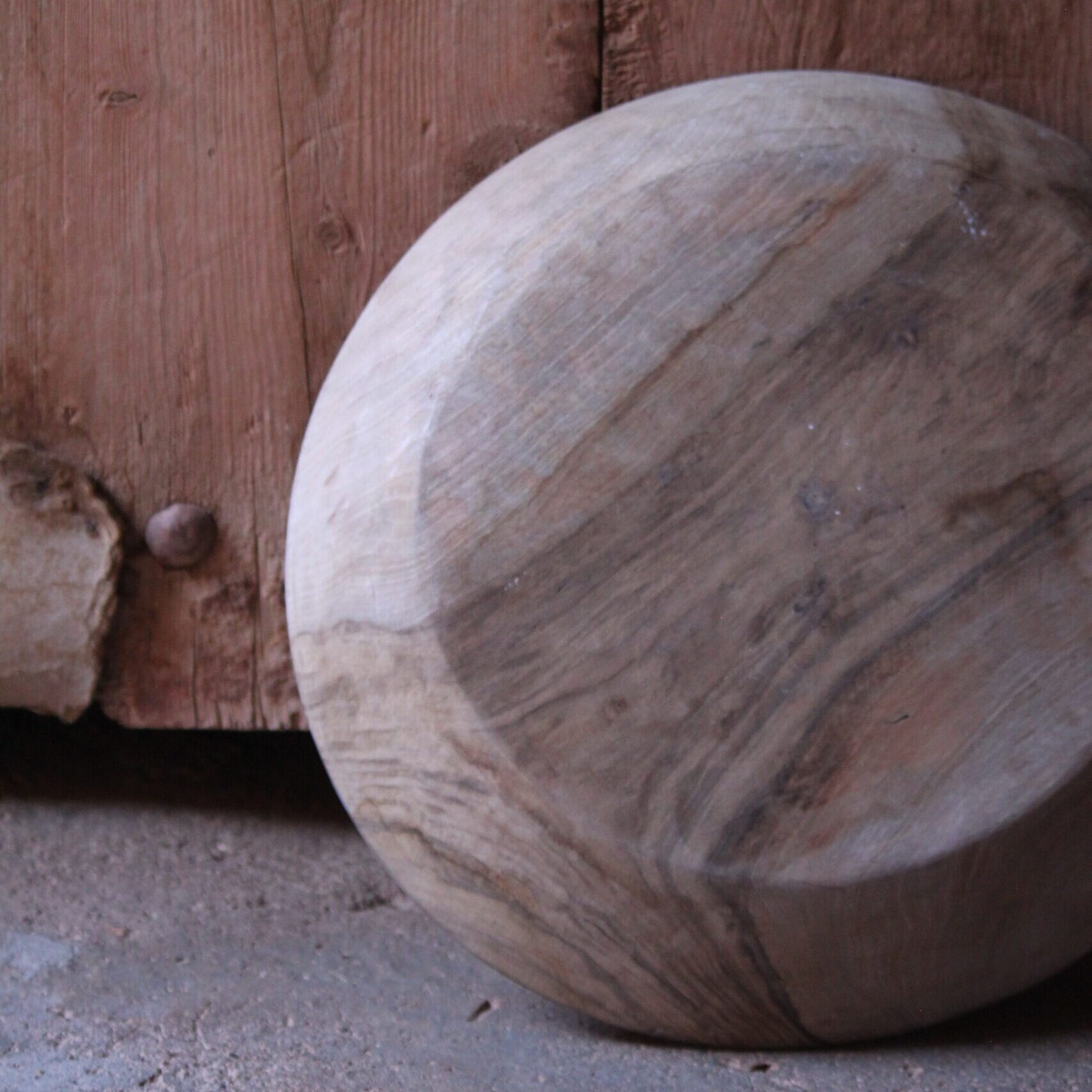 Grande assiette artisanale en bois de noyer, décorée de motifs géométriques amazighs sur le pourtour.
