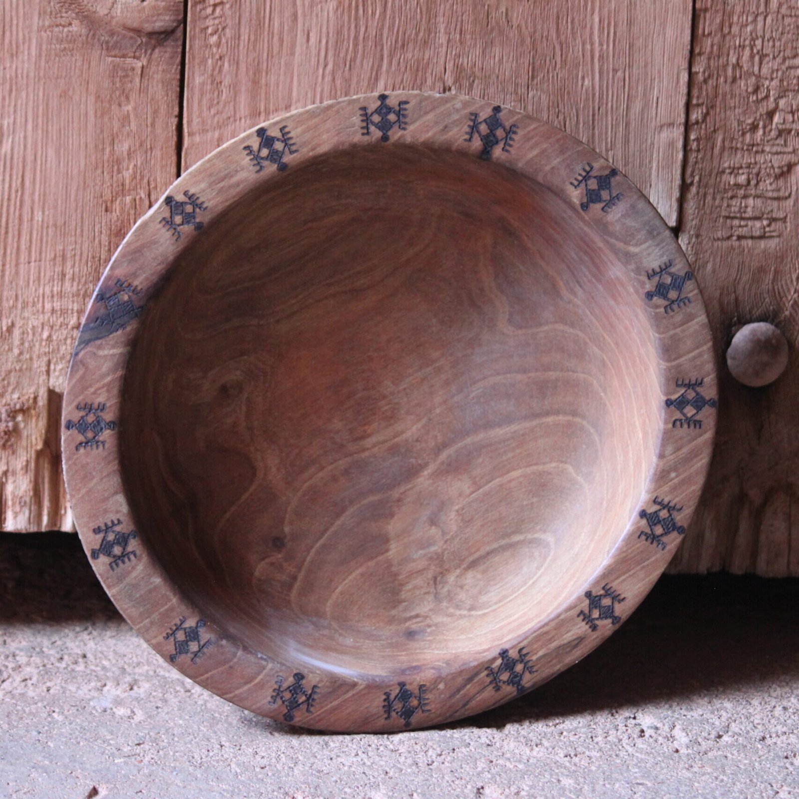 Assiette en bois de noyer façonnée à la main et ornée de motifs inspirés de la symbolique amazighe.