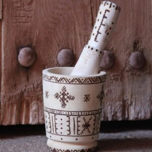 Mortier et pilon artisanaux en bois de tamarinier, décorés à la main de motifs géométriques amazighs.