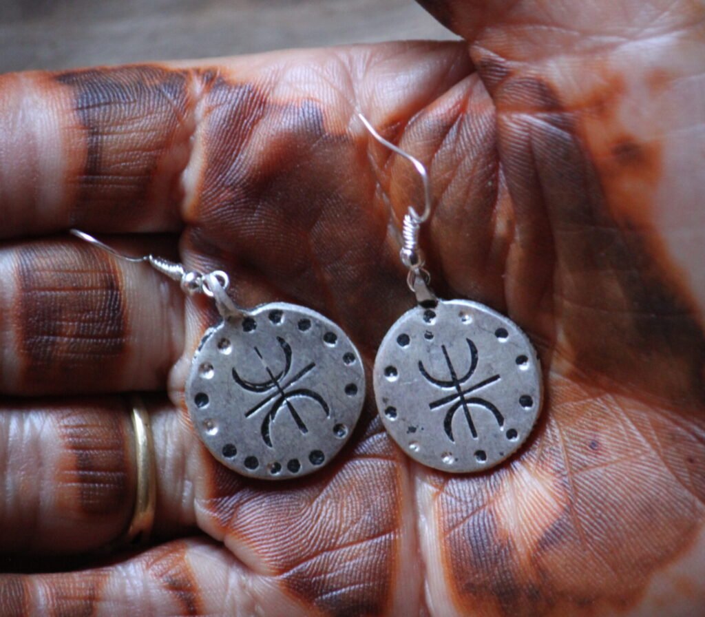 Boucles d’oreilles artisanales amazighes en métal plaqué argent, ornées de motifs traditionnels.