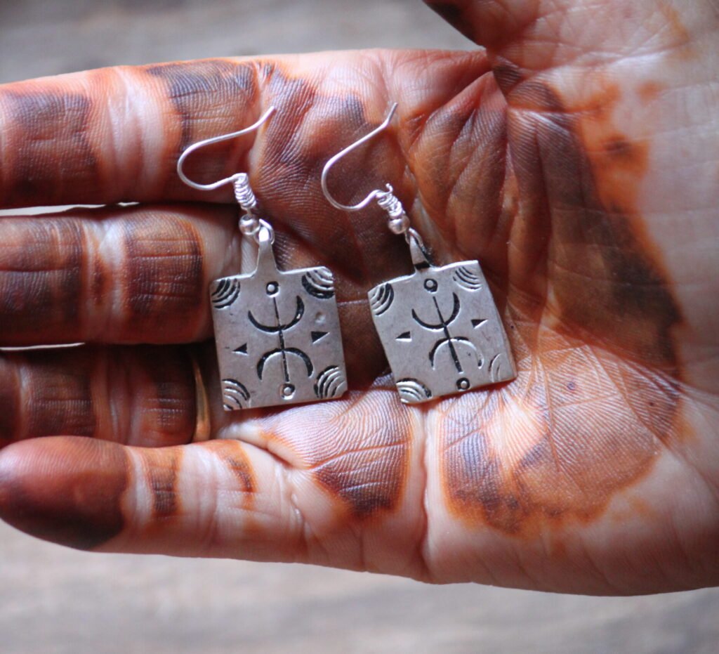 Boucles d’oreilles artisanales amazighes en métal plaqué argent, ornées de motifs traditionnels.