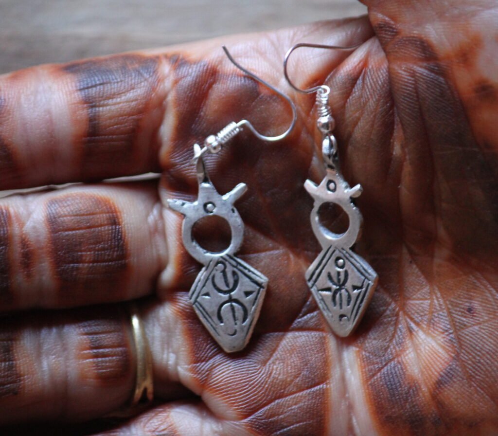 Boucles d’oreilles artisanales amazighes en métal plaqué argent, ornées de motifs traditionnels.