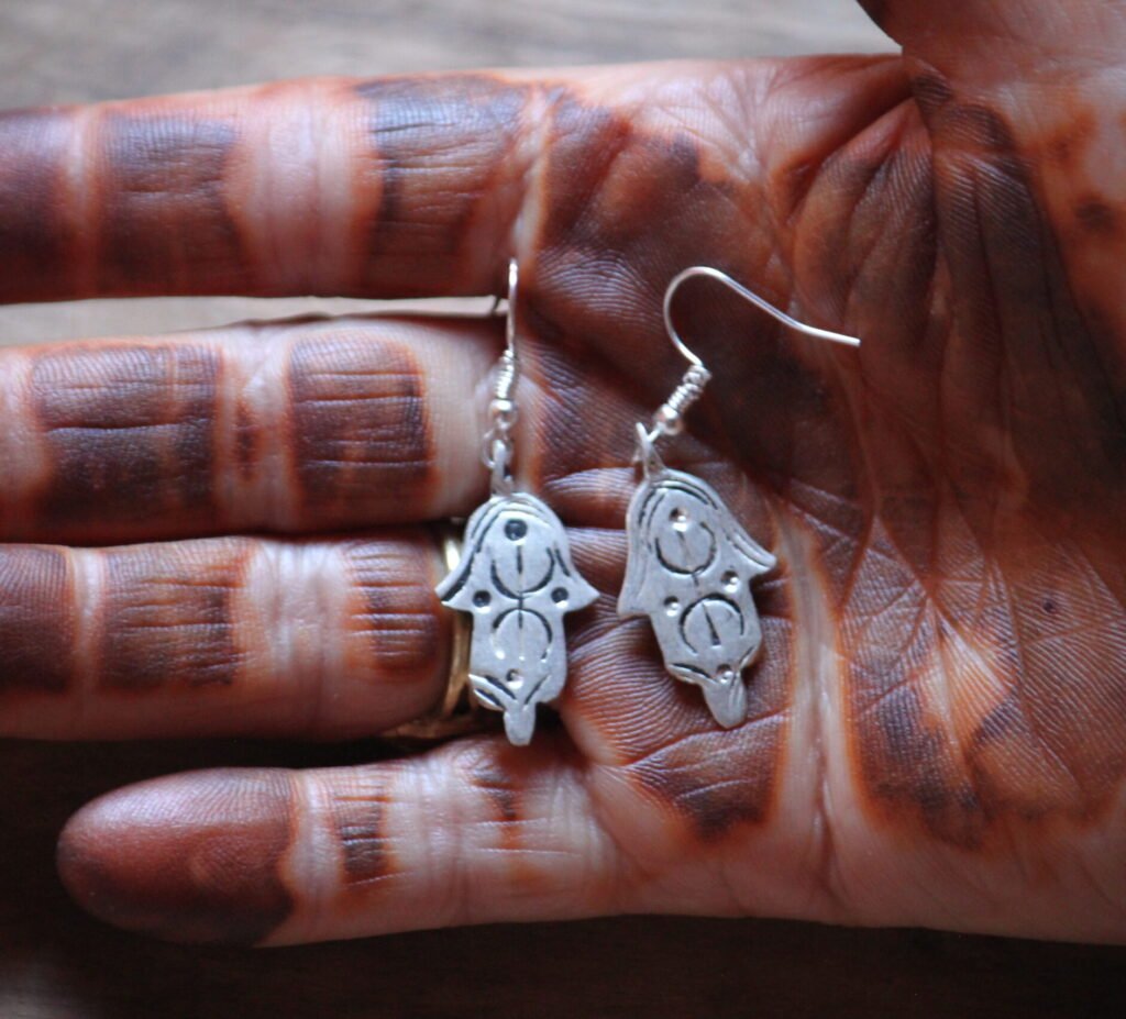 Boucles d’oreilles artisanales amazighes en métal plaqué argent, ornées de motifs traditionnels.