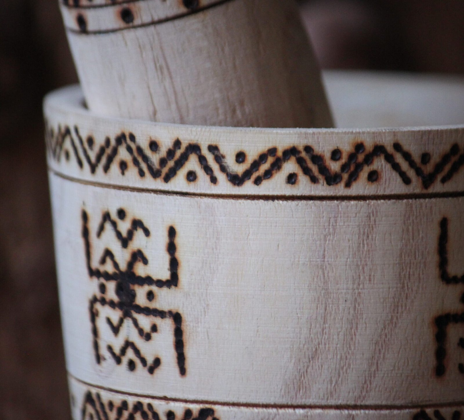 Mortier et pilon artisanaux en bois de tamarinier, décorés à la main de motifs géométriques amazighs.