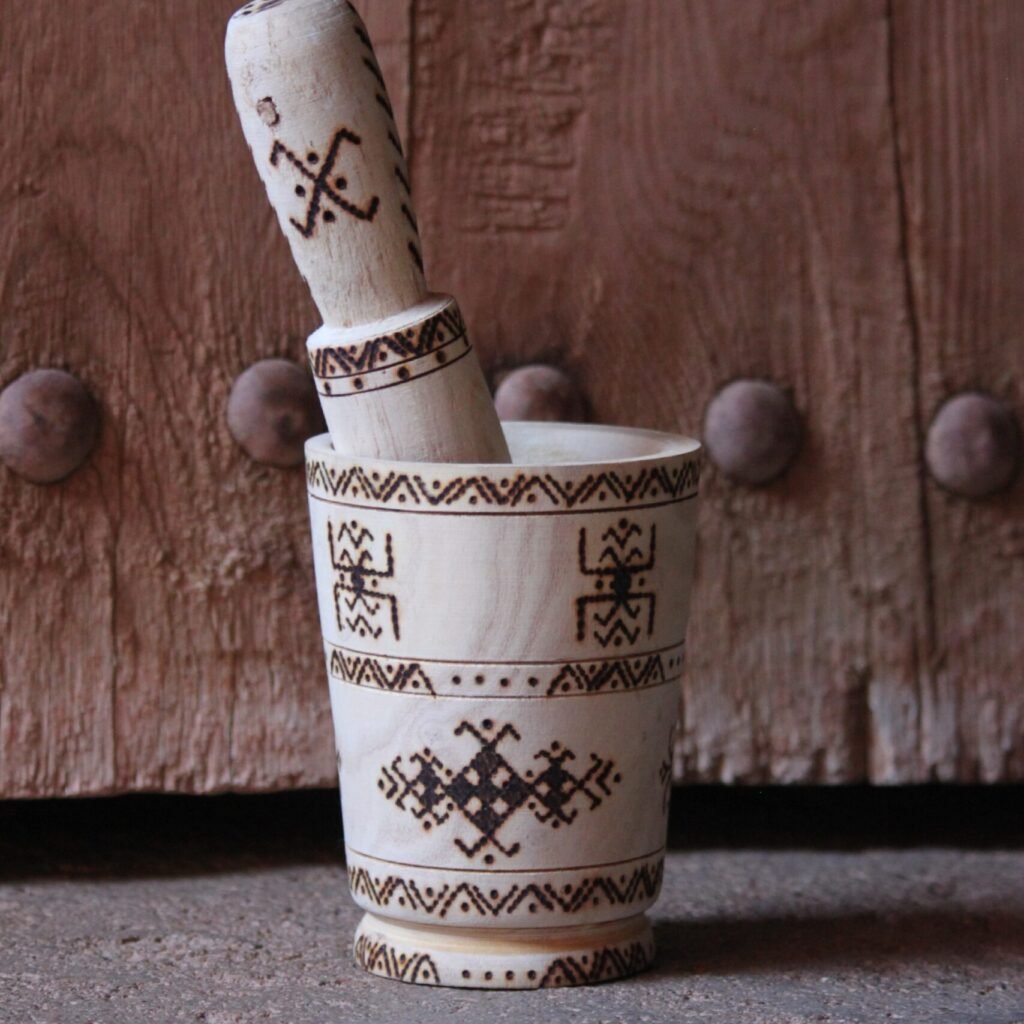 Mortier et pilon artisanaux en bois de tamarinier, décorés à la main de motifs géométriques amazighs.