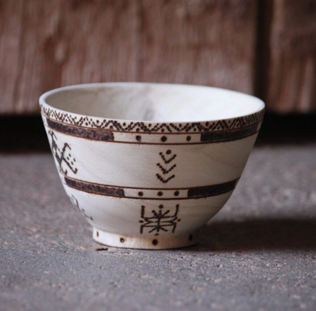 Bol artisanal en bois de tamarinier accompagné de trois cuillères décorées de motifs amazighs.