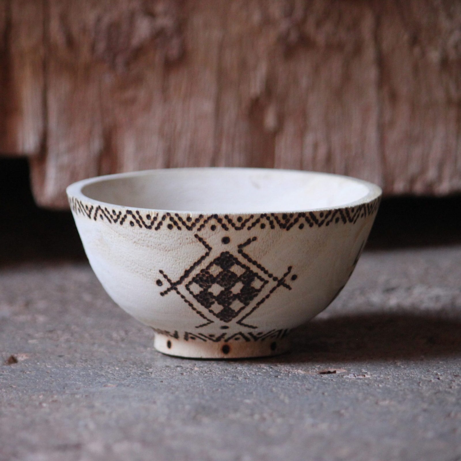 Bol artisanal en bois de tamarinier accompagné de trois cuillères décorées de motifs amazighs.