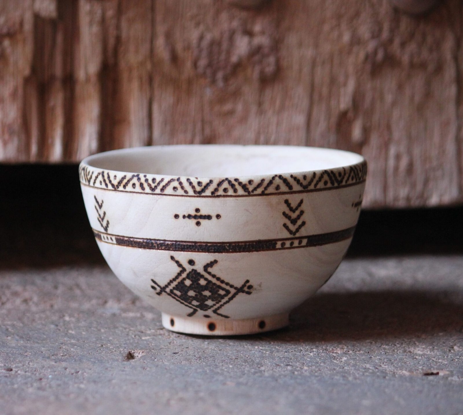 Bol artisanal en bois de tamarinier accompagné de trois cuillères décorées de motifs amazighs.