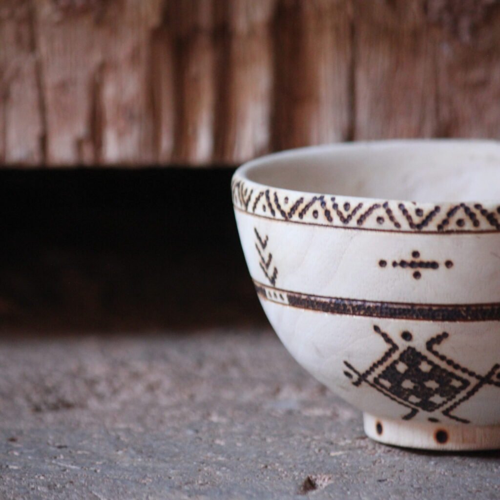 Bol artisanal en bois de tamarinier accompagné de trois cuillères décorées de motifs amazighs.