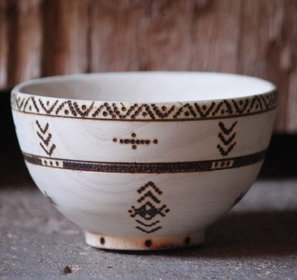Bol artisanal en bois de tamarinier accompagné de trois cuillères décorées de motifs amazighs.