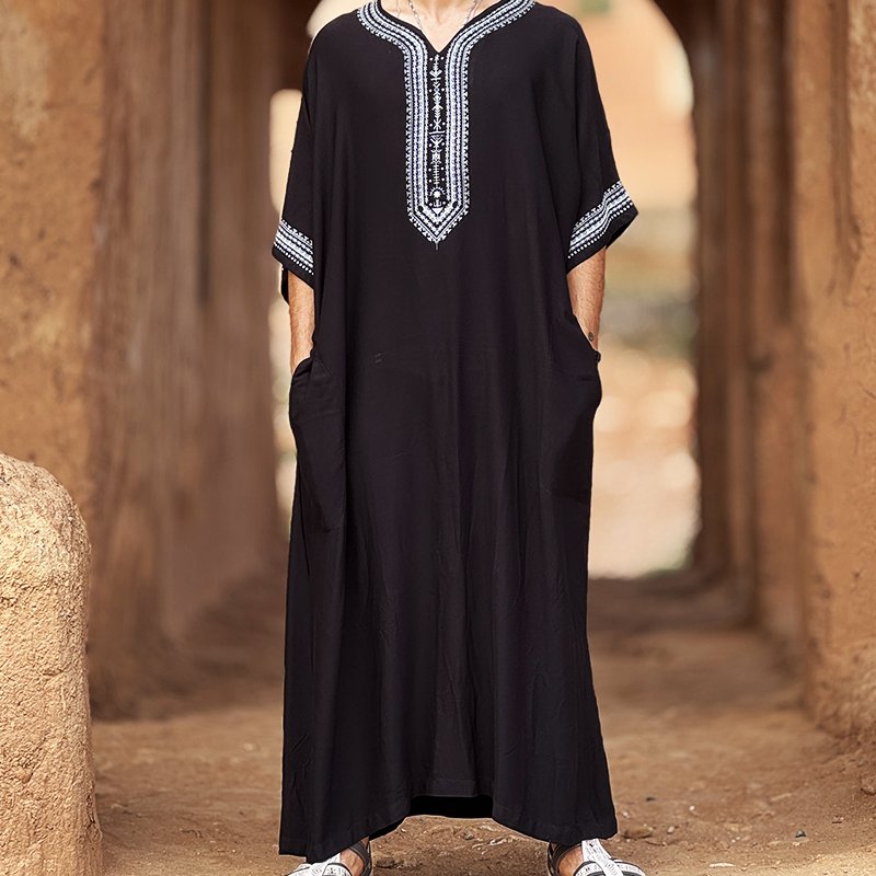 Homme portant une gandoura amazighe noire Afusart, décorée de motifs traditionnels contrastés.