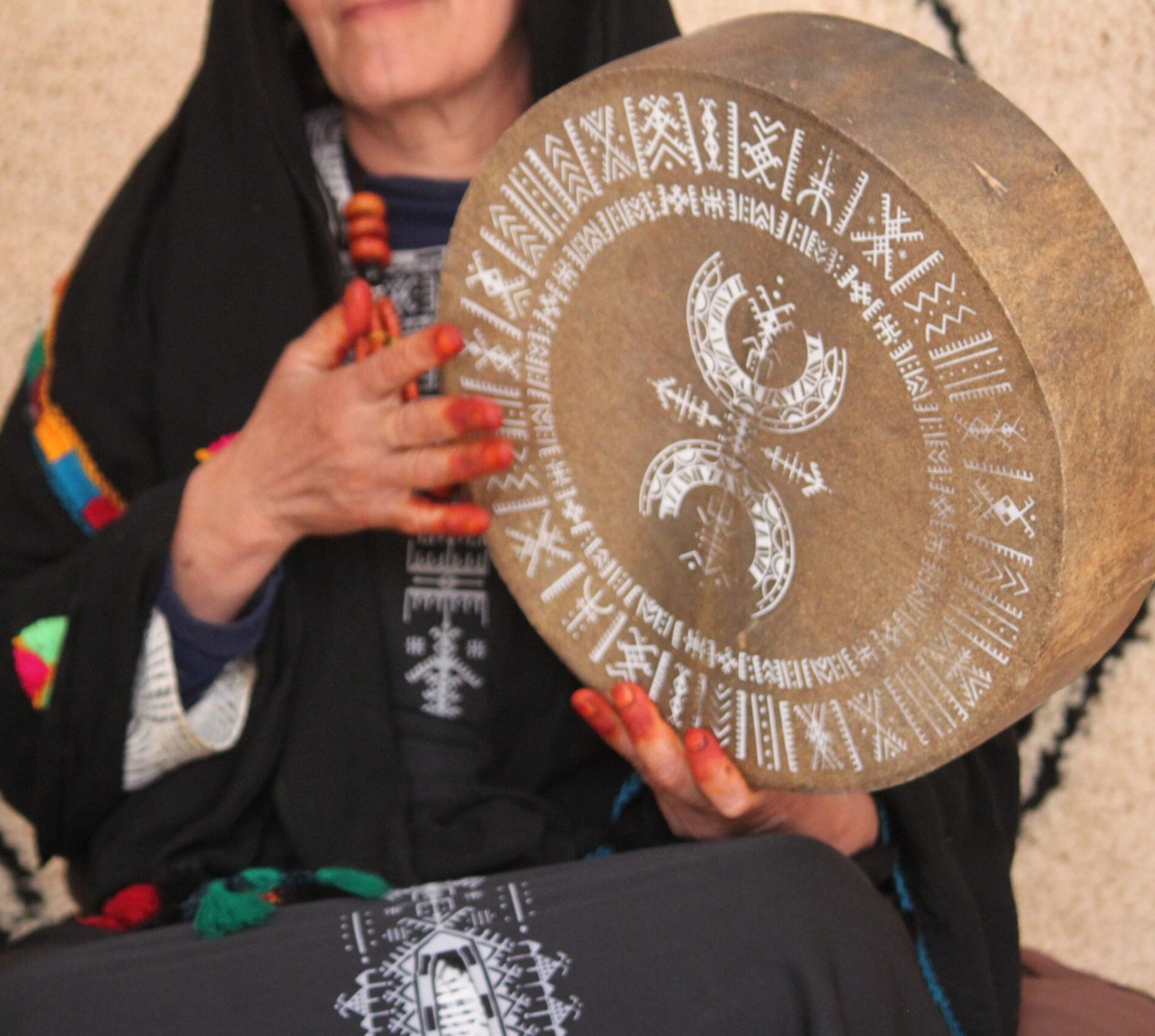 Bendir sérigraphié avec une illustration blanche de Muha Tawargit, composée de motifs géométriques amazighs en cercles concentriques.