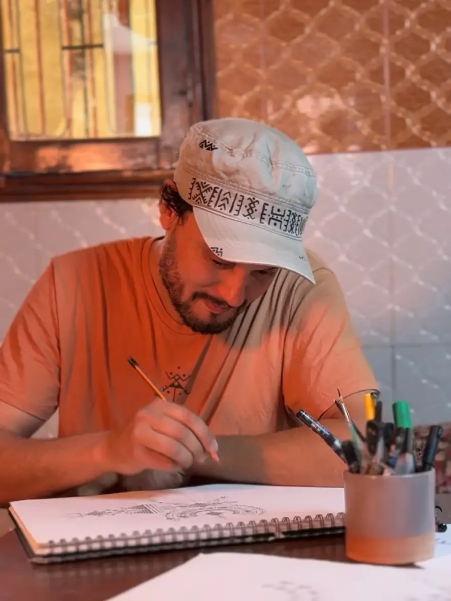 Moroccan artist Muha drawing traditional Amazigh symbols during a cultural workshop