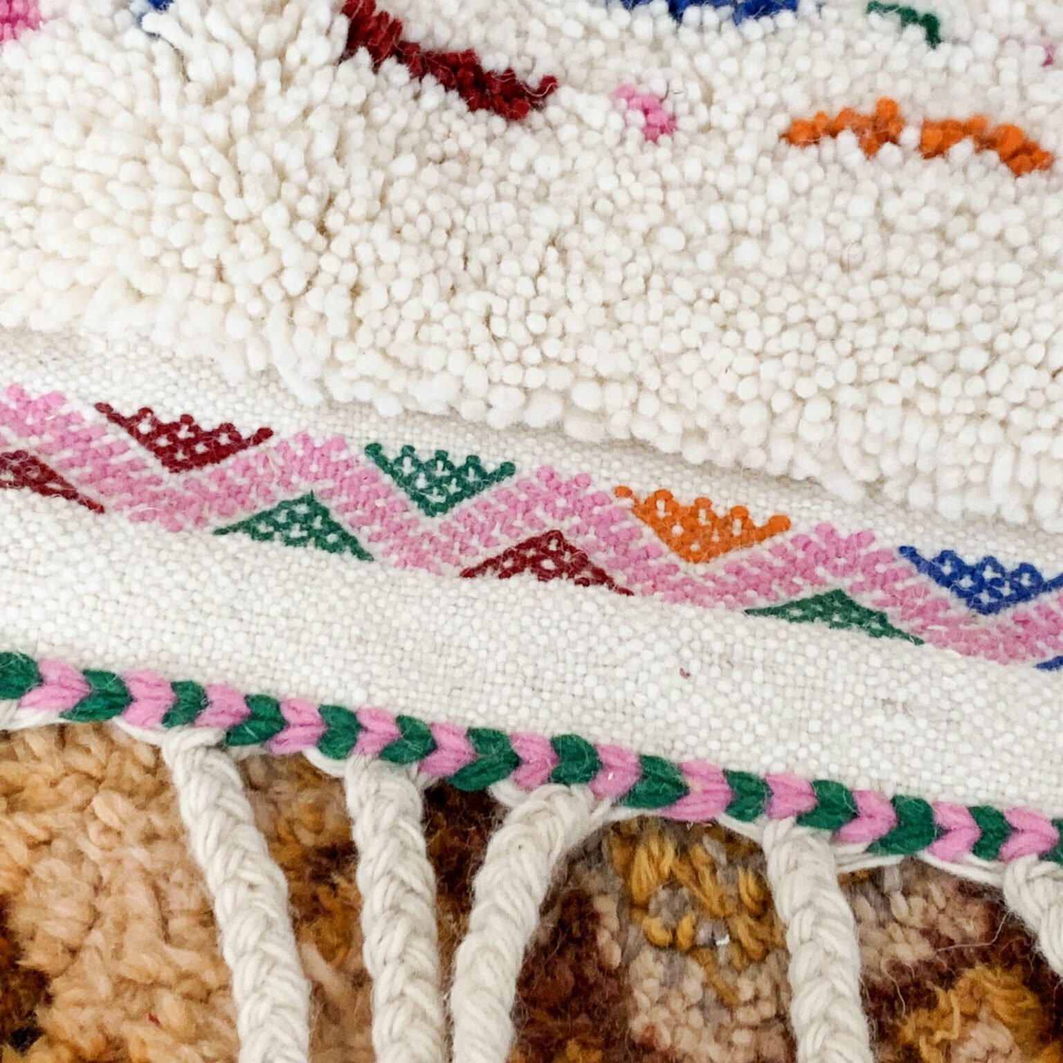 Tapis artisanal écru conçu par Afusart, tissé à la main par Malika, avec motifs amazighs noirs et touches colorées.