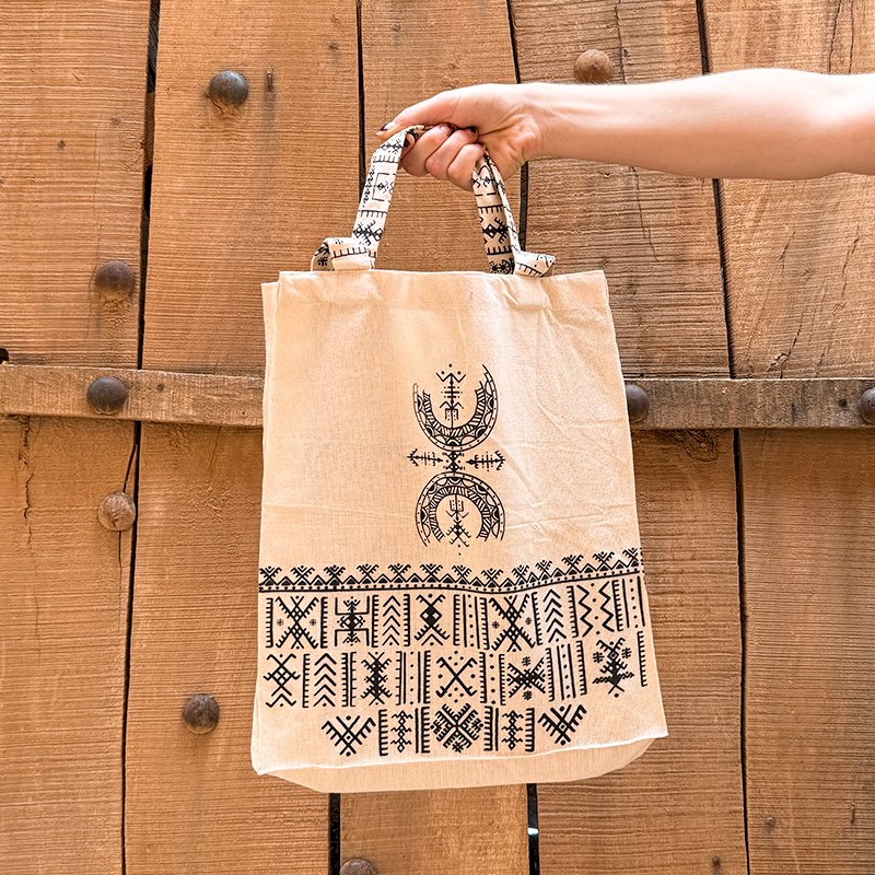 Tote bag beige au design unique Afusart, avec longues et petites anses décorées de motifs amazighs noirs.