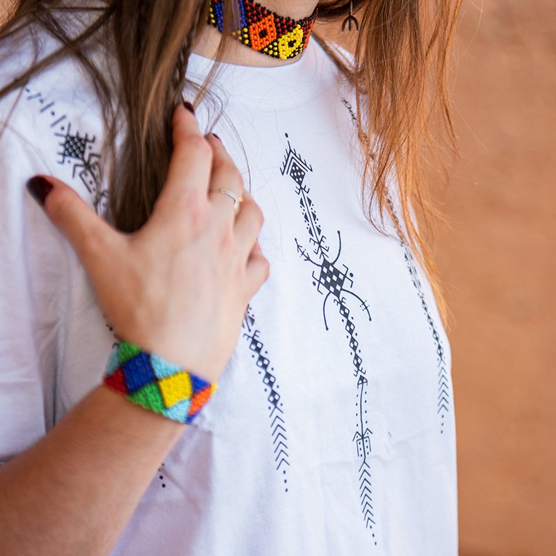 White Amazigh crop top featuring dark blue geometric and AZA-inspired decorative motifs