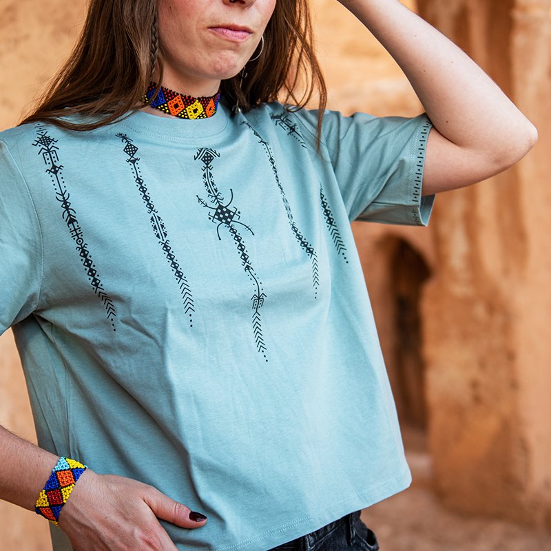 Light green Amazigh crop top with dark geometric motifs arranged vertically on the front