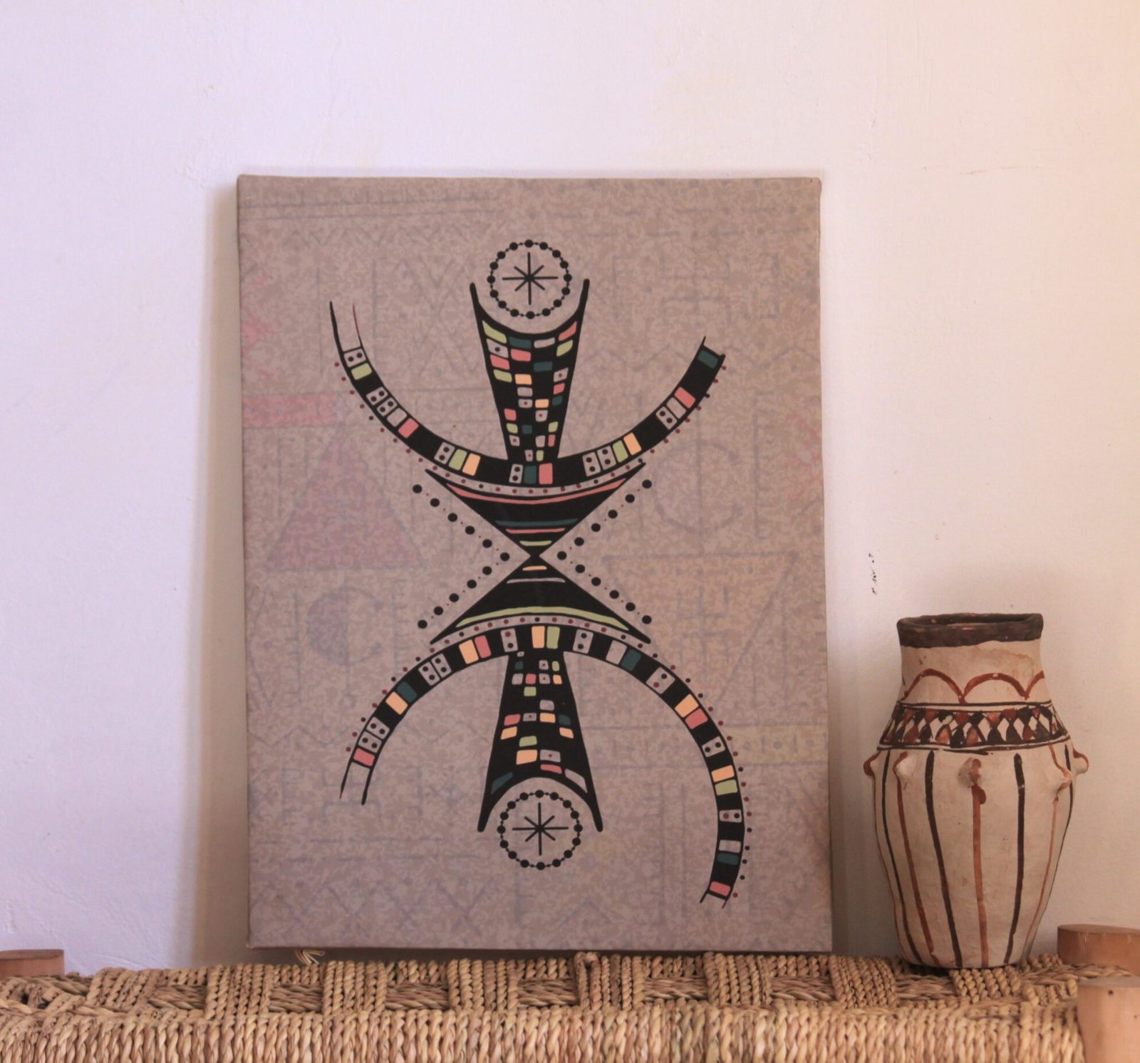 Illustration de Muha Tawargit inspirée du symbole amazigh Aza, composée de formes géométriques noires et de motifs colorés.