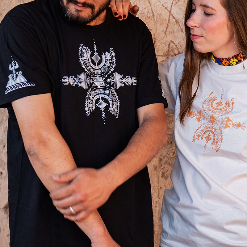 Homme et femme portant des t-shirts Afusart noir et blanc, ornés d’un design amazigh inspiré du symbole de liberté Aza.
